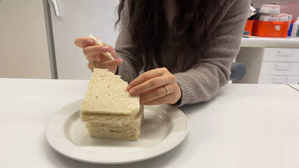 En deltagare i en studie äter bröd. Foto. 