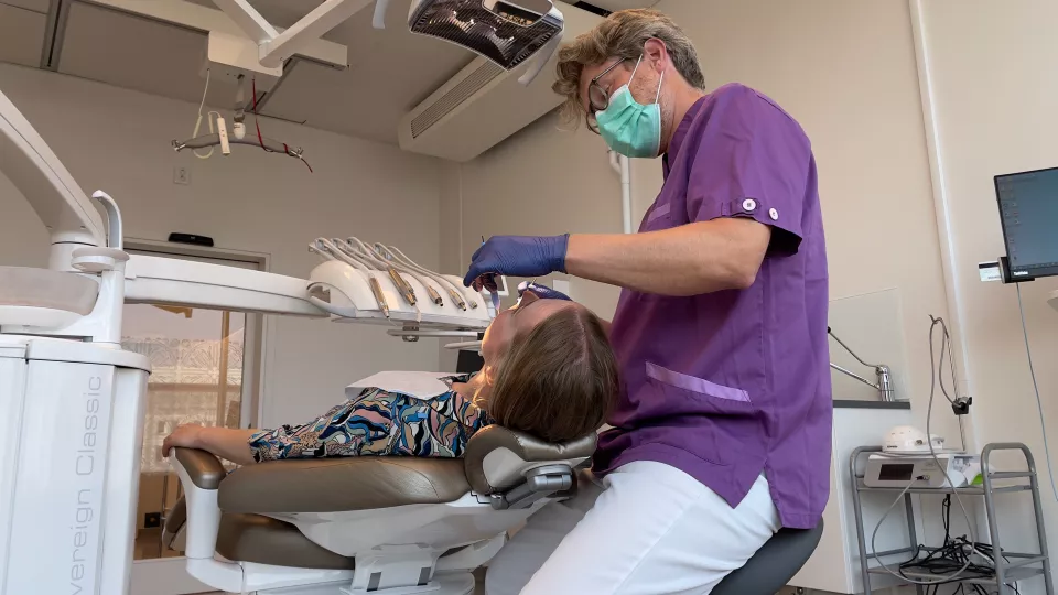 En tandläkare undersöker munhälsan hos en kvinna.