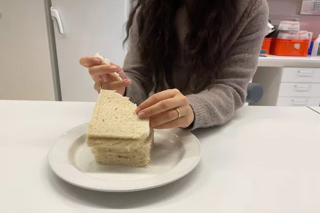 En deltagare i en studie äter bröd. Foto. 