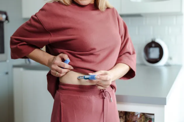 Foto av en kvinna som tar insulin.